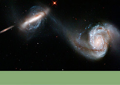 Foto mit Link zur Bildergalerie: Arp 87 - zwei benachbarte Galaxien, die durch eine "kosmische Brücke" aus Sternen, Staub- und Gasmassen miteinander verbunden sind